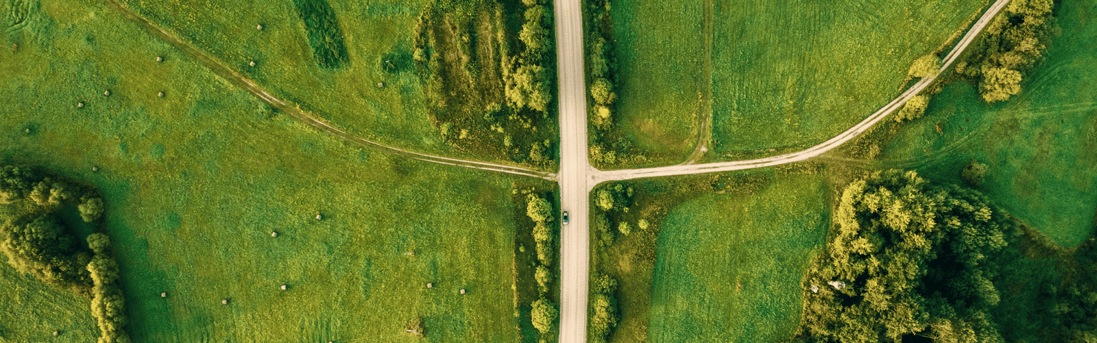 Une vue aérienne de deux routes qui se croisent au milieu d'un champ vert